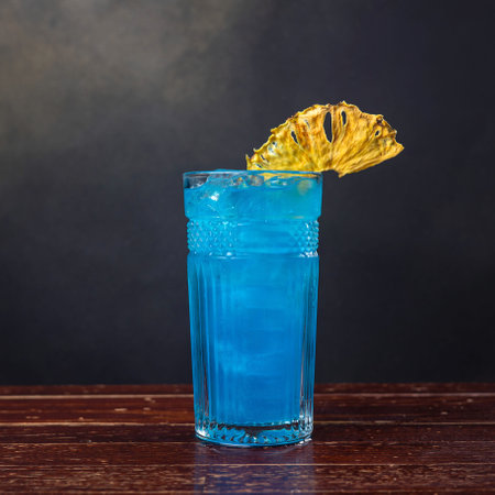 Blue Curacao cocktail with lemon slice and ice on wooden tableの写真素材