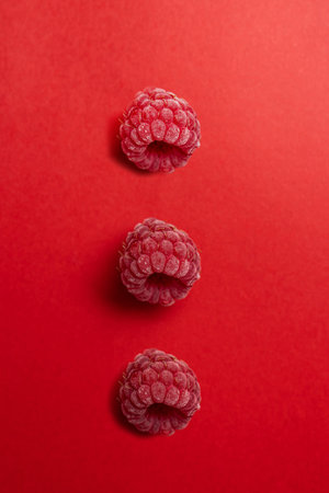 Raspberries on a red background. Flat lay, top view.の写真素材