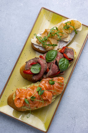 Bruschetta with salmon, mozzarella cheese and herbsの写真素材