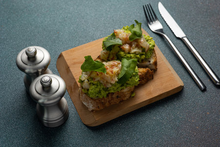 Sandwich with fried prawns and green peas on wooden boardの写真素材