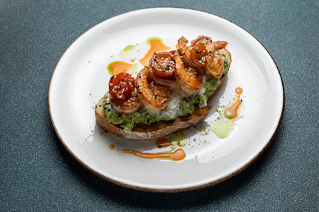 Sandwich with salmon, avocado and prawns on a white plateの写真素材