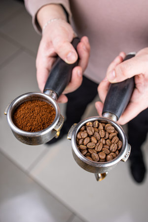Coffee grinder and ground coffee in the hands of a womanの写真素材