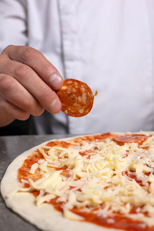Close-up of a man's hand holding a slice of pizzaの写真素材