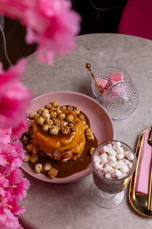Cake with caramel sauce and popcorn on a pink plate