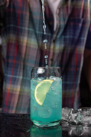 close up of a barman making a cocktail with ice and lemonの写真素材