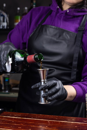 Bartender pouring red wine into a shaker at the barの写真素材