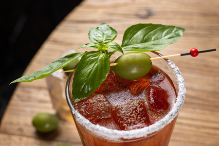 Cocktail with olives and basil on a wooden table.の写真素材
