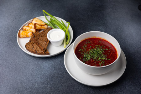Traditional Ukrainian borscht with sour cream and bread on a dark backgroundの写真素材