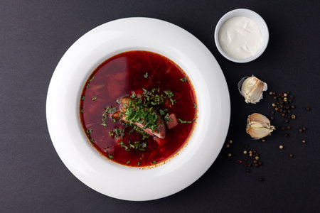 Traditional Russian borscht with meat and sour cream on a black backgroundの写真素材