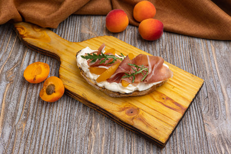 Canape with prosciutto and dried apricots on wooden boardの写真素材