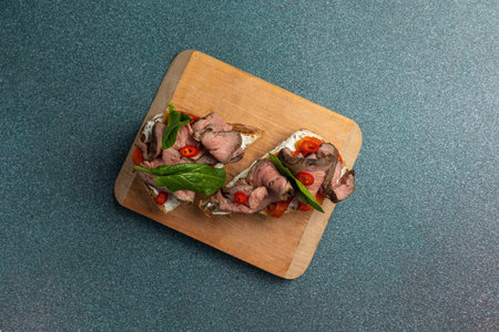 Canapes with meat and vegetables on a wooden board, top viewの写真素材