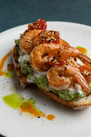 Tasty appetizer with shrimp and avocado on a white plate.の写真素材