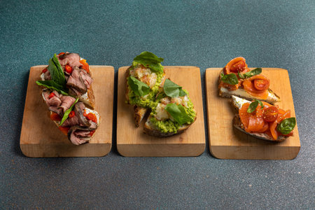 sandwiches with meat, vegetables and guacamole on wooden boardの写真素材