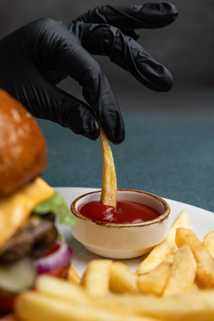 Hamburger with French fries and ketchup on a dark background