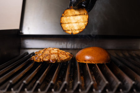 Cooking hamburger on a gas grill in the restaurant kitchen.