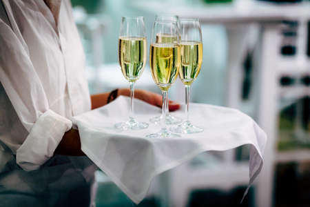 Waiter is carring plate with white Wine glasses.の写真素材