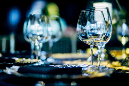 Luxury table settings for fine dining with and glassware, beautiful blurred  background. Preparation for holiday  Christmas and Hannukah dinner night.の写真素材