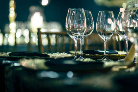 Luxury table settings for fine dining with and glassware, beautiful blurred  background. Preparation for holiday  Christmas and Hannukah dinner night.の写真素材