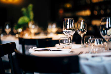 Luxury table settings for fine dining with and glassware, beautiful blurred  background. Preparation for holiday  Christmas and Hannukah dinner night.の写真素材