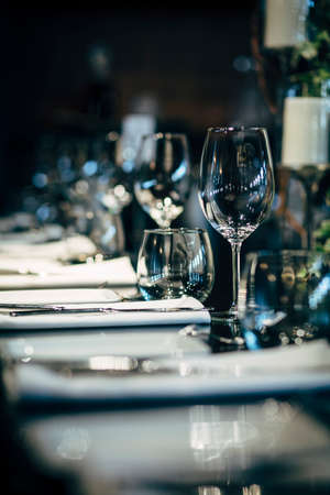 Luxury table settings for fine dining with and glassware, beautiful blurred  background. Preparation for holiday  Christmas and Hannukah dinner night.の写真素材