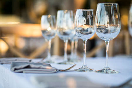 Luxury table settings for fine dining with and glassware, beautiful blurred  background. Preparation for holiday  Christmas and Hannukah dinner night.の写真素材