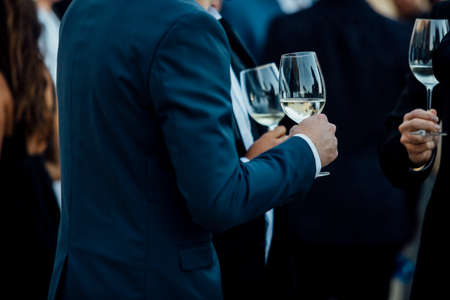 Couple of man  with a glass of wine at social event wearing elegant cloth.の写真素材