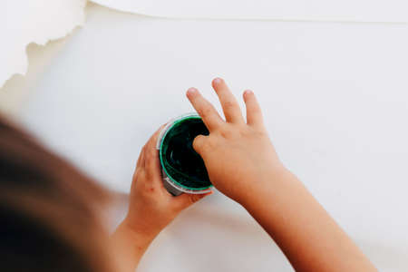 2-3 years old boys paint with hands on white paper, with bare hands, they using green, red and blue colour on white canvas paper.の写真素材