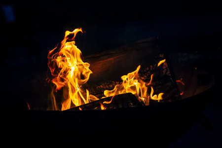 Night scene of fire sparks and flame burning with beautiful red flame.