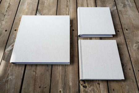 Wedding albums on beautiful wood background. Cloth cover without names. Can be used as design...