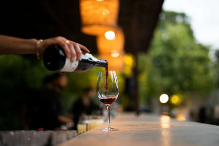 POURING RED WINE AT SOCIAL EVENT LIFE WEDDING PARTY OR OTHER LUXURY EVENT.の写真素材