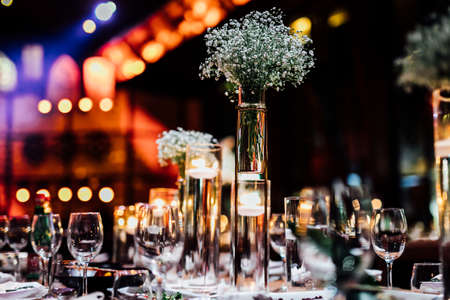 Luxury table settings for fine dining with and glassware, pouring wine to glass. Beautiful blurred background. Preparation for holiday wedding. Fancy luxury restaurant.の写真素材