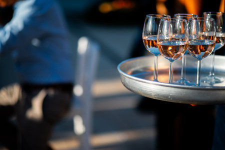 Luxury table settings for fine dining with and glassware, pouring wine to glass. Beautiful blurred...