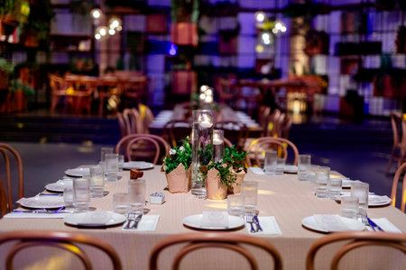 Luxury table settings for fine dining with and glassware, pouring wine to glass. Beautiful blurred...