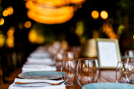 Luxury table settings for fine dining with and glassware, pouring wine to glass. Beautiful blurred...