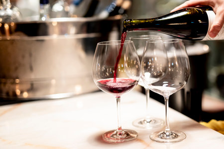 Pouring  red wine at luxury restaurant and luxury table settings. elegant light and dishes.