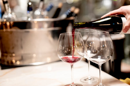Pouring  redcwine at luxury restaurant and luxuryy tabel settings. elegant light and dishes.の写真素材