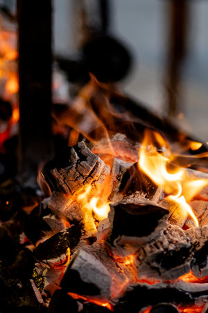 burning charcoal barbecue grill, fire burning in a evening blue light as a preparation to meat and fish meal outdoors. 2024 content.の写真素材