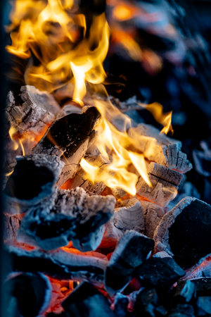 burning charcoal barbecue grill, fire burning in a evening blue light as a preparation to meat and fish meal outdoors. 2024 content.の写真素材