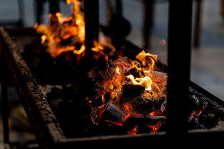 burning charcoal barbecue grill, fire burning in a evening blue light as a preparation to meat and...