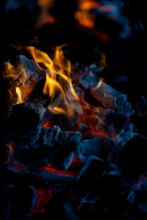 burning charcoal barbecue grill, fire burning in a evening blue light as a preparation to meat and fish meal outdoors. 2024 content.の写真素材