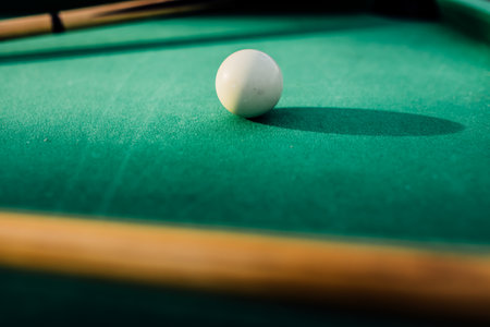 A pool table with scattered billiard balls, a cue stick, and accessories captured in a dynamic, game-ready scene. The detailed focus on the equipment highlights the timeless appeal of billiards as both a sport and a leisure activityの写真素材