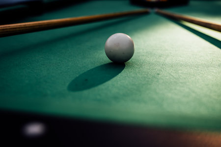 A pool table with scattered billiard balls, a cue stick, and accessories captured in a dynamic, game-ready scene. The detailed focus on the equipment highlights the timeless appeal of billiards as both a sport and a leisure activityの写真素材