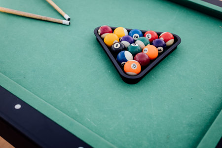 A pool table with scattered billiard balls, a cue stick, and accessories captured in a dynamic, game-ready scene. The detailed focus on the equipment highlights the timeless appeal of billiards as both a sport and a leisure activityの写真素材