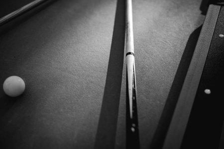 A pool table with scattered billiard balls, a cue stick, and accessories captured in a dynamic, game-ready scene. The detailed focus on the equipment highlights the timeless appeal of billiards as both a sport and a leisure activityの写真素材