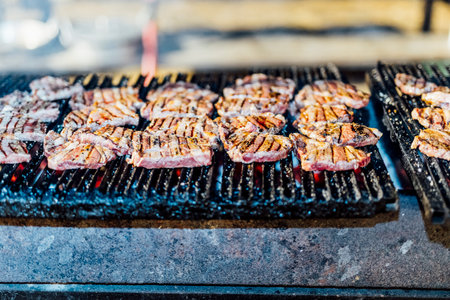 Juicy smoked beef brisket being freshly sliced on a wooden cutting board during a barbecue event. Close-up of tender meat with a charred crust, captured in natural light for a rustic and authentic culinary feel.âの写真素材