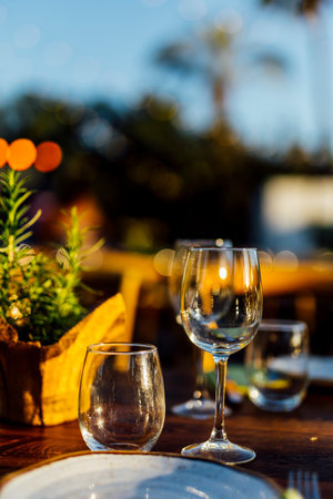 Romantically set dinner table with wine glasses and floral centerpiece, perfect for a wedding,...
