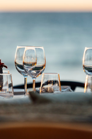 An elegant table setting with cutlery, wine glasses, and white napkins, illuminated by soft natural light. Perfect for interior design, events, or hospitality concepts.の写真素材