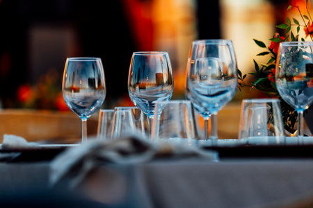 An elegant table setting with cutlery, wine glasses, and white napkins, illuminated by soft natural light. Perfect for interior design, events, or hospitality concepts.の写真素材