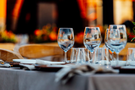 An elegant table setting with cutlery, wine glasses, and white napkins, illuminated by soft natural light. Perfect for interior design, events, or hospitality concepts.の写真素材