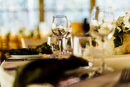 An elegant table setting with cutlery, wine glasses, and white napkins, illuminated by soft natural light. Perfect for interior design, events, or hospitality concepts.の写真素材
